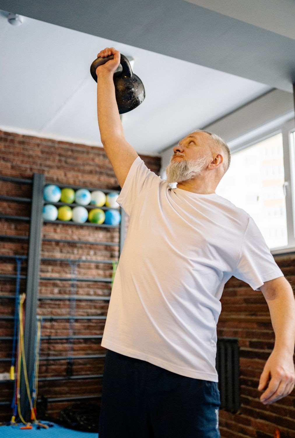 Older adult performing a kettlebell exercise at a fitness studio on the Upper West Side