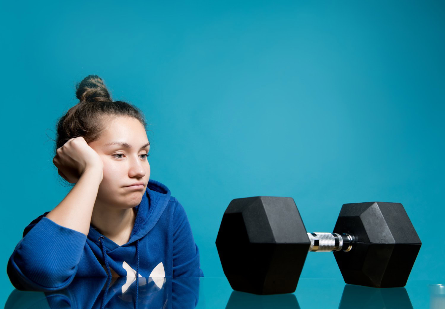 Beginner staring at a dumbbell before her first strength training session in NYC