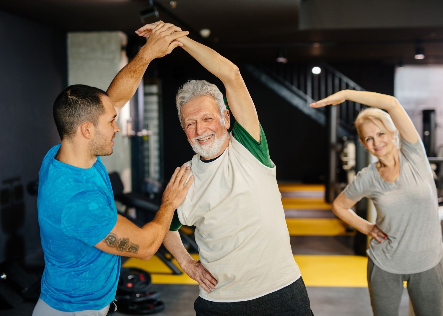 Personal trainer guiding senior client through a mobility stretch at Momentum Fitness NYC