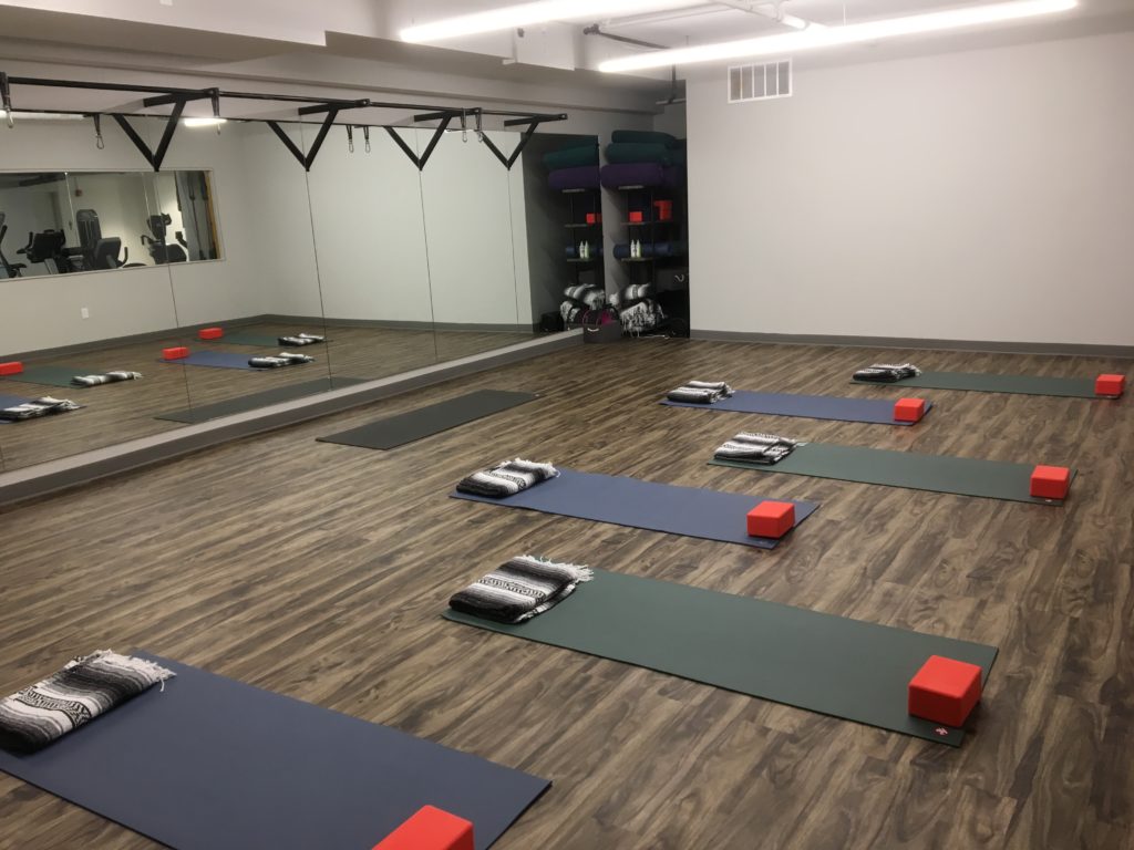Yoga and Pilates studio with mirrors and hardwood flooring
